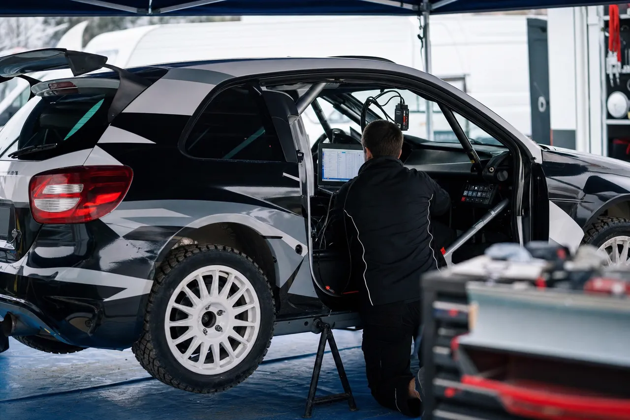 Rally electronics being serviced on a car in a service park.